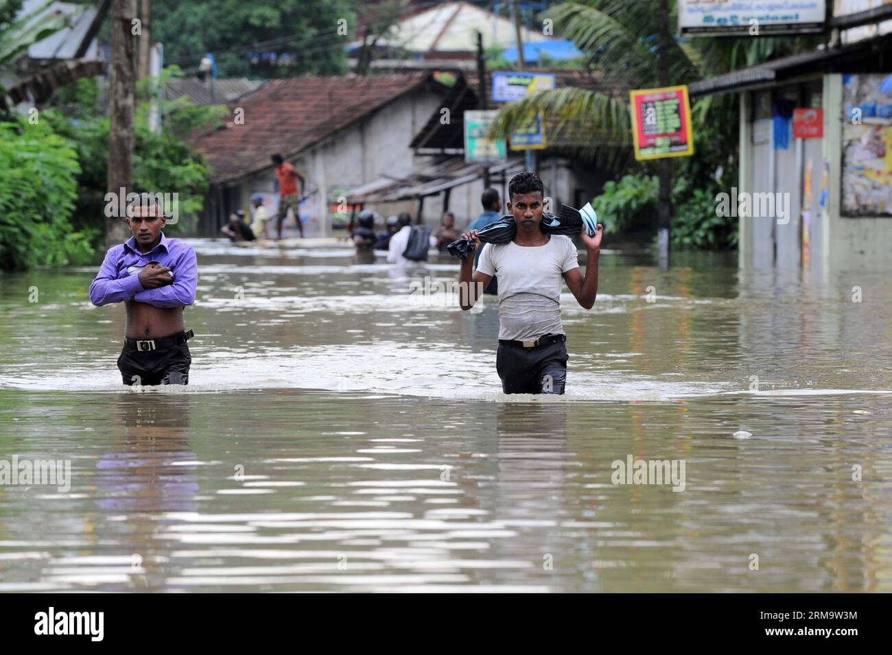 (140602) -- COLOMBO, 2 juin 2014 (Xinhua) -- les gens parcourent une sortie inondée de la principale autoroute du Sri Lanka après que de fortes pluies de mousson ont frappé les régions ouest et sud de l'île à Colombo, Sri Lanka, le 2 juin 2014. Les inondations et les glissements de terrain à la suite de fortes pluies qui ont frappé des parties du Sri Lanka ont tué 14 personnes lundi, a déclaré le Centre de gestion des catastrophes. (Xinhua/P.Karunaratne) (zjy) SRI LANKA-COLOMBO-WEATHER-DEATH PUBLICATIONxNOTxINxCHN Colombo juin 2 2014 célébrités XINHUA veau à travers une sortie inondée de la route express principale sud du Sri Lanka après que de fortes pluies de mousson ont frappé l'ouest et le sud de l'Islande Banque D'Images