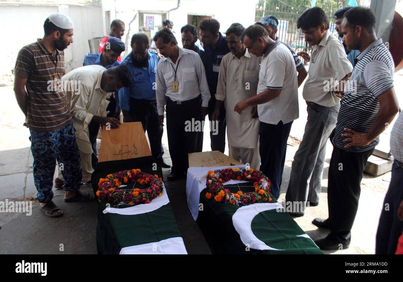 Le personnel de la Force de sécurité de l'aéroport pakistanais (ASF) et les membres de leur famille se rassemblent aux côtés des cercueils de collègues tués lors d'un assaut par des militants sur l'aéroport de Karachi, dans la ville portuaire de Karachi, dans le sud du Pakistan, le 9 juin 2014. Les corps de sept personnes portées disparues à la suite d une attaque meurtrière à l aéroport international Jinnah de Karachi, ville portuaire du sud du Pakistan, ont été retrouvés mardi matin, portant le nombre de morts dans l incident à 38, dont 10 militants, ont indiqué des responsables. (Xinhua/Arshad) PAKISTAN-KARACHI-ATTACK PUBLICATIONxNOTxINxCHN Pakistan Airport Security Force ASF Perso Banque D'Images
