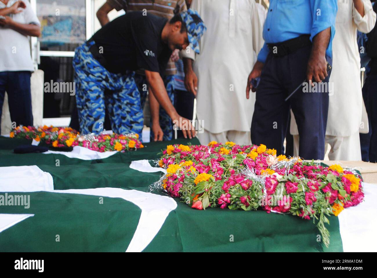 Le personnel de la Force de sécurité de l'aéroport pakistanais (ASF) et les membres de leur famille se rassemblent aux côtés des cercueils de collègues tués lors d'un assaut par des militants sur l'aéroport de Karachi, dans la ville portuaire de Karachi, dans le sud du Pakistan, le 9 juin 2014. Les corps de sept personnes portées disparues à la suite d une attaque meurtrière à l aéroport international Jinnah de Karachi, ville portuaire du sud du Pakistan, ont été retrouvés mardi matin, portant le nombre de morts dans l incident à 38, dont 10 militants, ont indiqué des responsables. (Xinhua/Arshad) PAKISTAN-KARACHI-ATTACK PUBLICATIONxNOTxINxCHN Pakistan Airport Security Force ASF Perso Banque D'Images