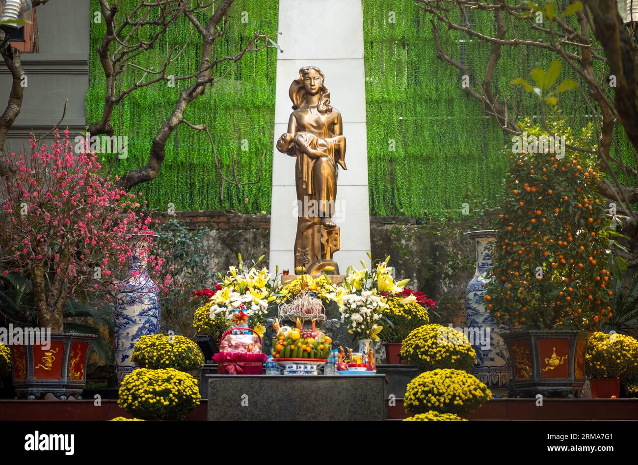 Une statue d'une femme tenant un enfant mort entouré de fleurs et d'offrandes au mémorial de la guerre aux 287 personnes mortes de la bombe de Noël américaine Banque D'Images