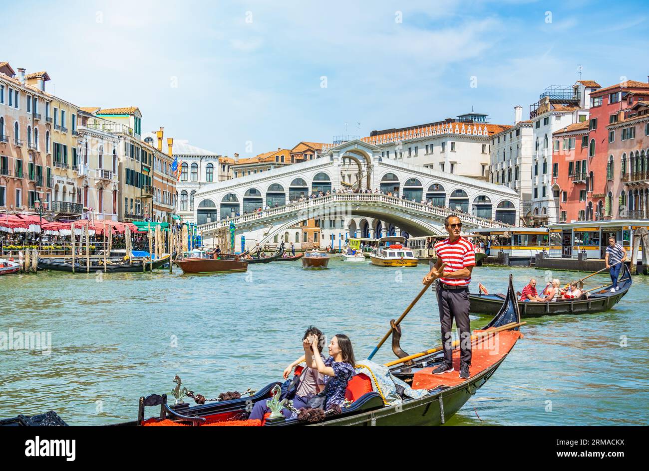 Venise, Italie - Mai 30 2023 : promenade traditionnelle en gondole sur le Grand Canal près du pont du Rialto (Ponte di Rialto). Touristes à Venise. Banque D'Images
