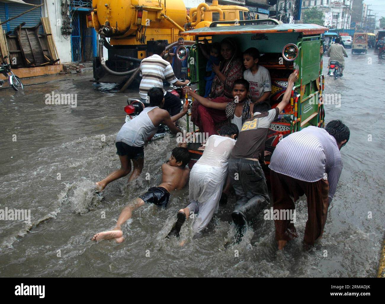 (140703) -- LAHORE, 3 juillet 2014 (Xinhua) -- des enfants poussent un pousse-pousse automatique sur une route inondée sous de fortes pluies à Lahore, dans l'est du Pakistan, le 3 juillet, 2014.(Xinhua/Sajjad) PAKISTAN-LAHORE-PLUIE LOURDE PUBLICATIONxNOTxINxCHN Lahore juillet 3 2014 des enfants de XINHUA poussent vers un pousse-pousse de voiture SUR une route inondée pendant de fortes pluies dans l'est du Pakistan S Lahore juillet 3 2014 XINHUA Sajjjad Pakistan Lahore pluie lourde PUBLICATIONxNOTxINxCHN Banque D'Images