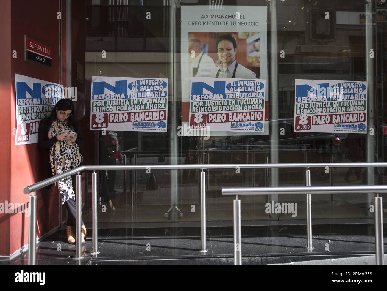 BUENOS AIRES, 8 juillet 2014 (Xinhua) -- Une femme vérifie son téléphone devant une succursale d'une banque toujours fermée, lors d'un arrêt de travail de 24 heures organisé par l'Association bancaire, dans la ville de Buenos Aires, capitale de l'Argentine, le 8 juillet 2014. L'arrêt de travail a été mené en réclamation pour les licenciements et agressions dans la province de Tucuman et pour une restructuration de l'impôt sur les bénéfices. (Xinhua/Martin Zabala) (jp) (rt) ARGENTINA-BUENOS AIRES-SOCIETY-STRIKE PUBLICATIONxNOTxINxCHN Buenos Aires juillet 8 2014 XINHUA une femme vérifie son téléphone devant une succursale d'une banque Thatcher Banque D'Images