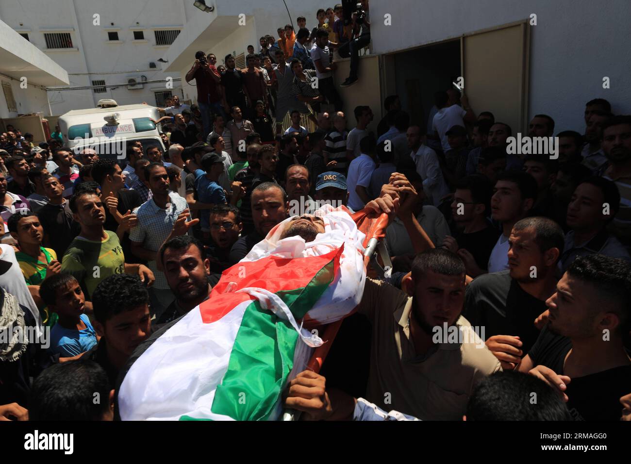 (140709) -- GAZA, 9 juillet 2014 (Xinhua) -- des Palestiniens portent le corps d'un membre d'une famille Hamad lors de leurs funérailles dans la ville de Beit Hanun, dans le nord de la bande de Gaza, le 9 2014 juillet. Six membres d'une famille Hamad ont été tués après une frappe israélienne visant leur maison dans le nord de Gaza, ont déclaré des médecins, le deuxième jour de l'opération israélienne contre les militants palestiniens. L'armée de l'air israélienne a bombardé 160 cibles dans la bande de Gaza pendant la nuit alors qu'elle menait une campagne à grande échelle pour arrêter les tirs de roquettes palestiniennes, a déclaré un responsable de l'armée. Au moins 27 personnes ont été tuées depuis le début Banque D'Images