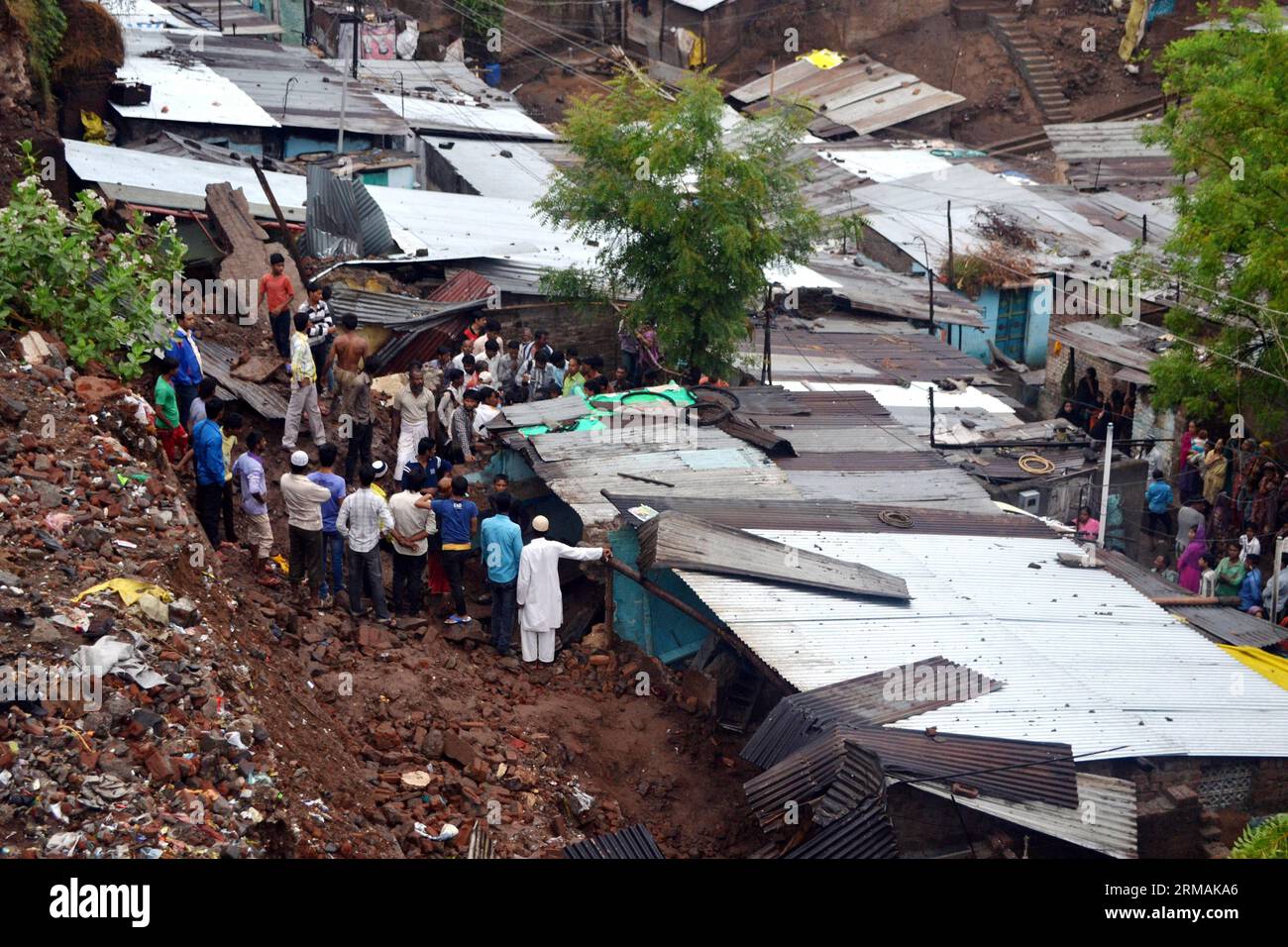 Les habitants se rassemblent sur le site après l'effondrement d'un mur de maison à Doulatpura, dans l'État indien central du Madhya Pradesh, le 14 juillet 2014. Au moins sept enfants ont été tués et sept autres personnes blessées dans un effondrement du mur en raison de fortes pluies dans l'État indien central du Madhya Pradesh dimanche soir, a déclaré lundi un haut responsable de la police. (Xinhua/Stringer) INDE-MADHYA PRADESH-EFFONDREMENT DU MUR PUBLICATIONxNOTxINxCHN des habitants se rassemblent SUR le site après l'effondrement d'un mur de maison dans l'État indien central du Madhya Pradesh juillet 14 2014 au moins sept enfants ont été TUÉS et sept autres Celebri Banque D'Images