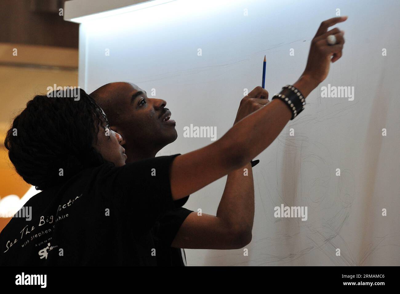 (140716) -- SINGAPOUR, 16 juillet 2014 (Xinhua) -- l'artiste autiste britannique Stephen Wiltshire (à droite) dessine assisté de sa sœur Annette le premier jour de son apparition au Paragon Shopping Centre de Singapour, le 16 juillet 2014. Singapore Press Holdings (SPH) a invité Stephen Wiltshire à dresser un panorama de Singapour mercredi. (Xinhua/puis Chih Wey) SINGAPORE-ARTIST-STEPHEN WILTSHIRE PUBLICATIONxNOTxINxCHN Singapour juillet 16 2014 XINHUA Britain S artiste autiste Stephen Wiltshire r dessine assisté par sa sœur Annette LE premier jour de son apparition dans Singapore S Paragon Shopping C. Banque D'Images