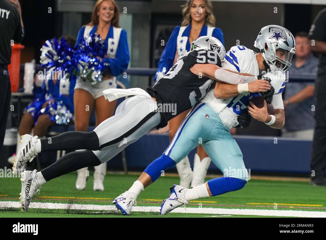 Le quarterback des Dallas Cowboys Will Grier (15 ans) est affronté par le linebacker des Las Vegas Raiders Luke Masterson (59 ans) lors d'un match de pré-saison de la NFL entre les Las Vegas Raiders et les Dallas Cowboys au ATT Stadium d'Arlington, Texas, le 26 août 2023. Les Cowboys ont battu les Raiders 31-16. (Max Siker / image du sport) Banque D'Images