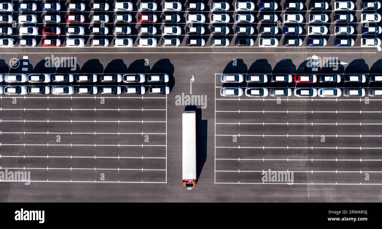 Une vue aérienne directement au-dessus de rangées de voitures nouvellement construites dans l'industrie automobile sur un quai commercial prêt à être chargé pour l'exportation et l'importation Banque D'Images