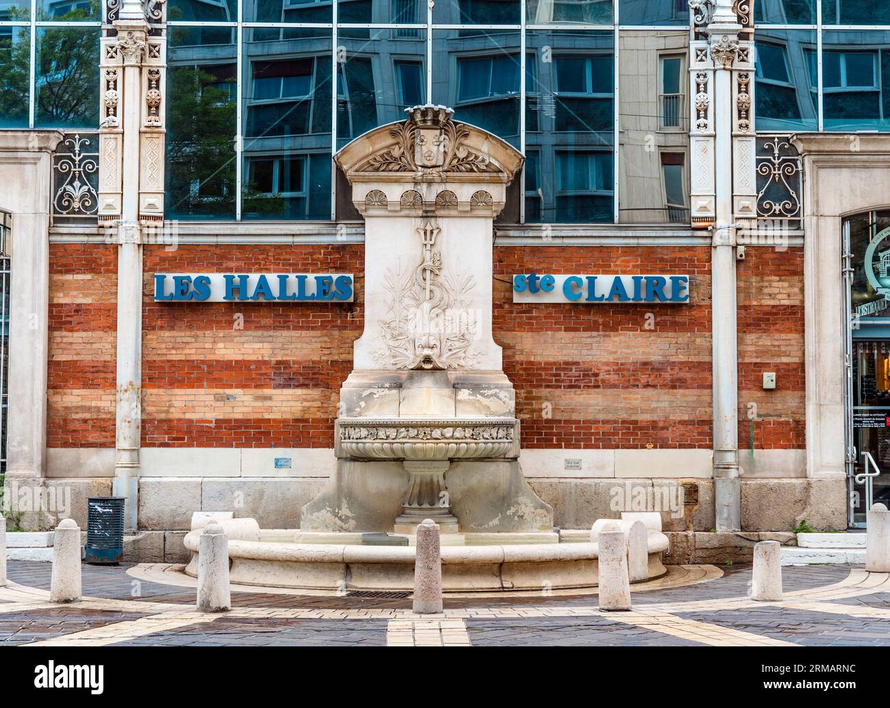 La fontaine avec dauphin stylisé devant les Halle Sainte-Claire, marché historique du 19e siècle dans le centre-ville de Grenoble, France Banque D'Images
