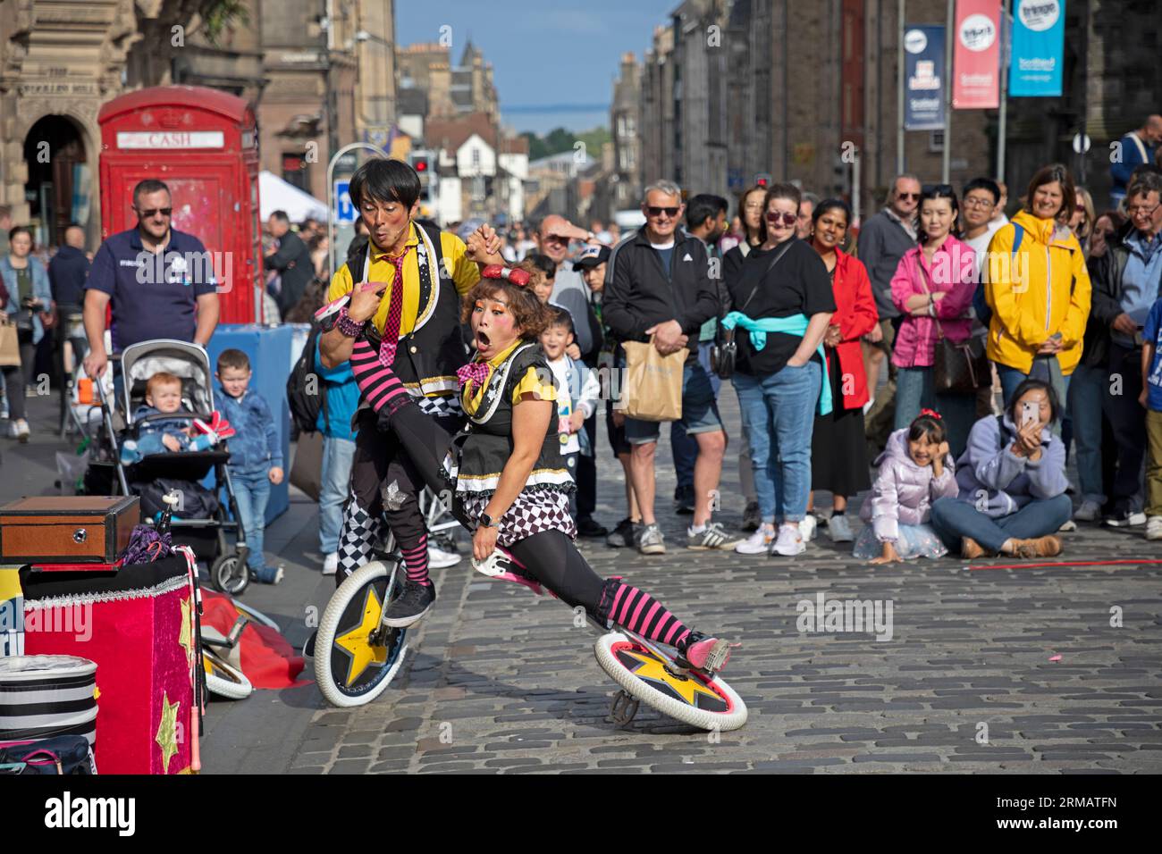 Royal Mile, Édimbourg, Écosse, Royaume-Uni. 27 août 2023. Bien que le Fringe Festival d'Édimbourg se termine le lundi 28 août, il n'y avait pas de sécurité ou de personnel Fringe autour de la High Street pour surveiller les foules et le temps des spectacles d'artistes de rue. Cependant, il y avait encore un large public congressant pour se divertir. Sur la photo : Witty Looks Cheeky et Daiki du Japon divertissent la foule avec leur numéro de comédie sur le terrain de High Street inférieur. Crédit : Arch White/alamy Live News. Banque D'Images