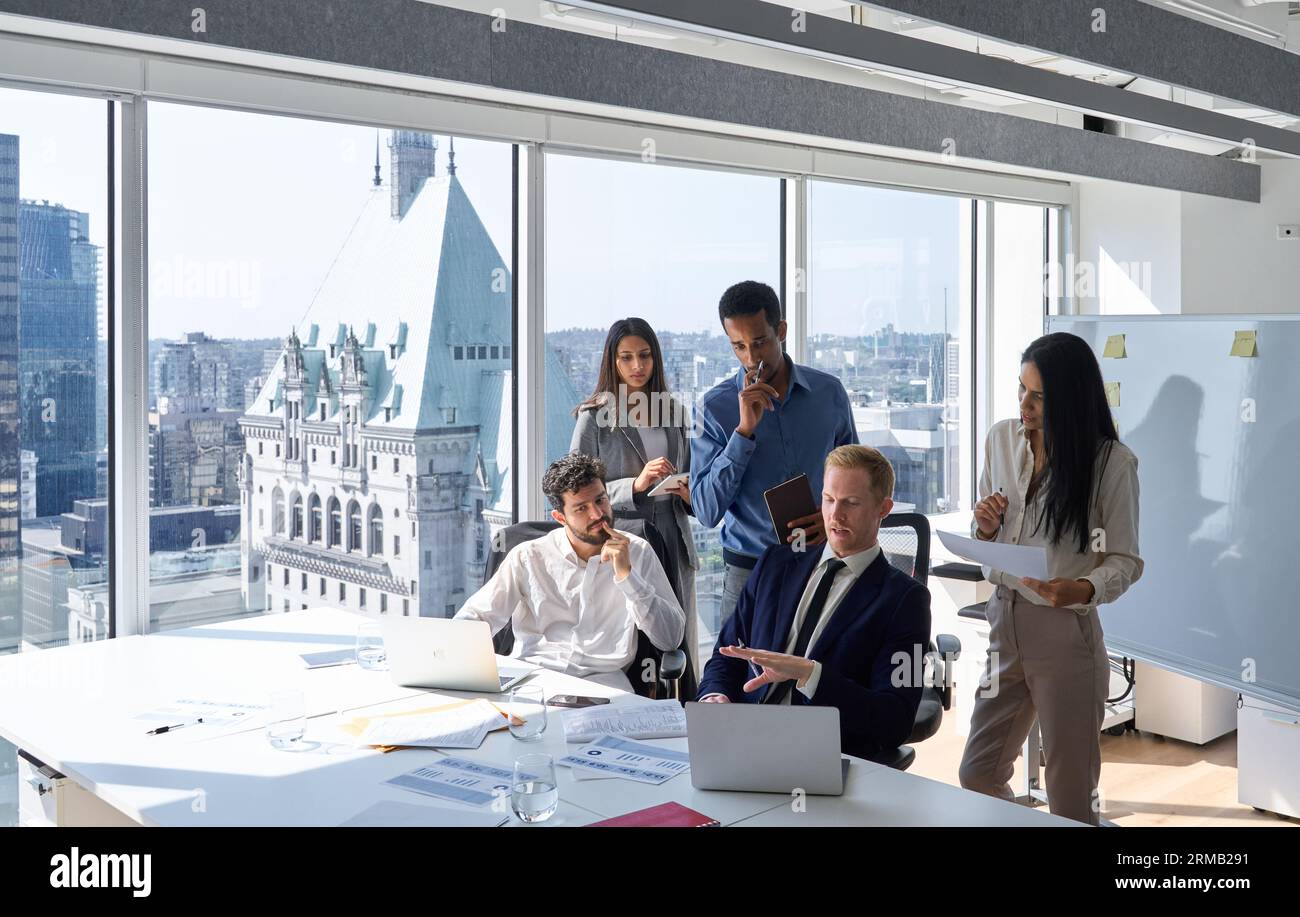 Équipe de travail professionnelle diversifiée occupée travaillant sur ordinateur portable au bureau. Banque D'Images