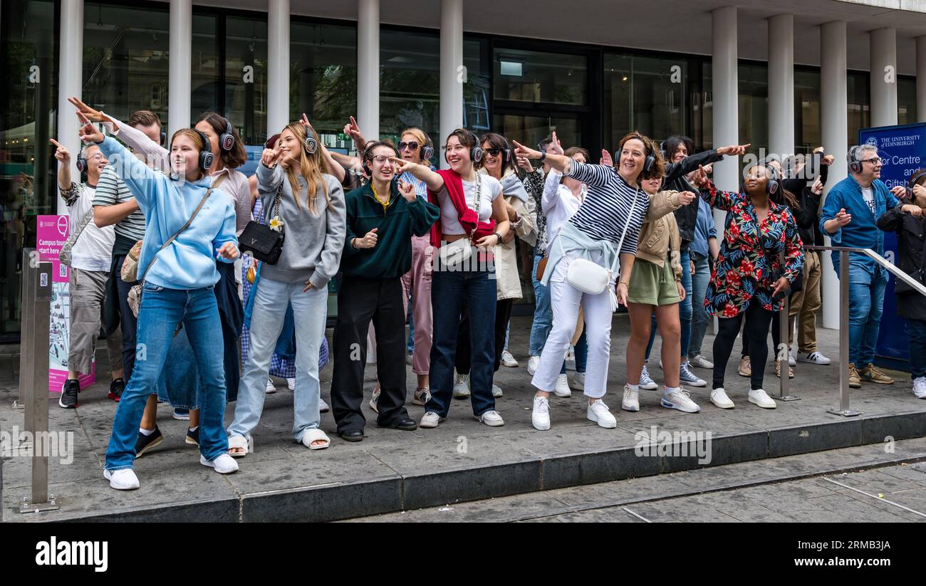 Édimbourg, Écosse, Royaume-Uni, 27 août 2023. Silent Disco : un grand groupe aime la musique à travers des écouteurs alors qu'ils sont conduits autour de la ville dansant sur la musique pop seulement ils peuvent entendre. Crédit : Sally Anderson/Alamy Live News Banque D'Images