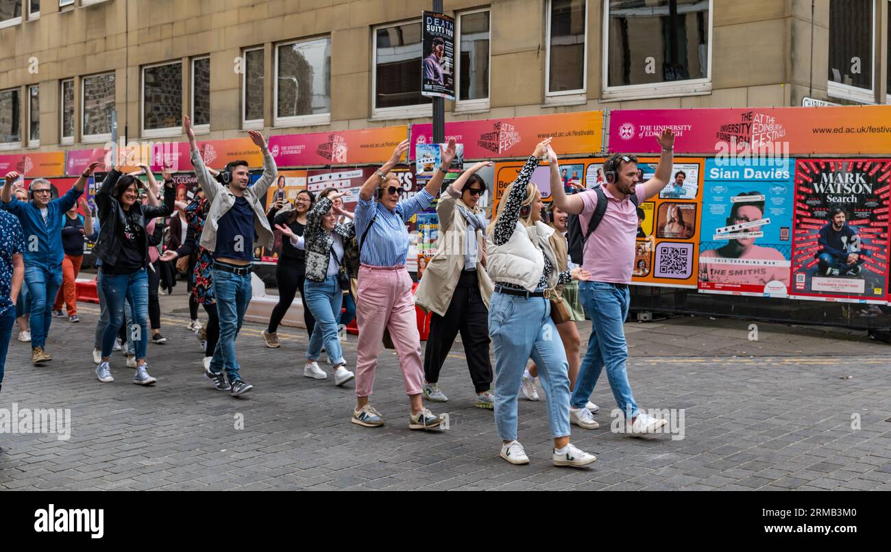 Édimbourg, Écosse, Royaume-Uni, 27 août 2023. Silent Disco : un grand groupe aime la musique à travers des écouteurs alors qu'ils sont conduits autour de la ville dansant sur la musique pop seulement ils peuvent entendre. Crédit : Sally Anderson/Alamy Live News Banque D'Images