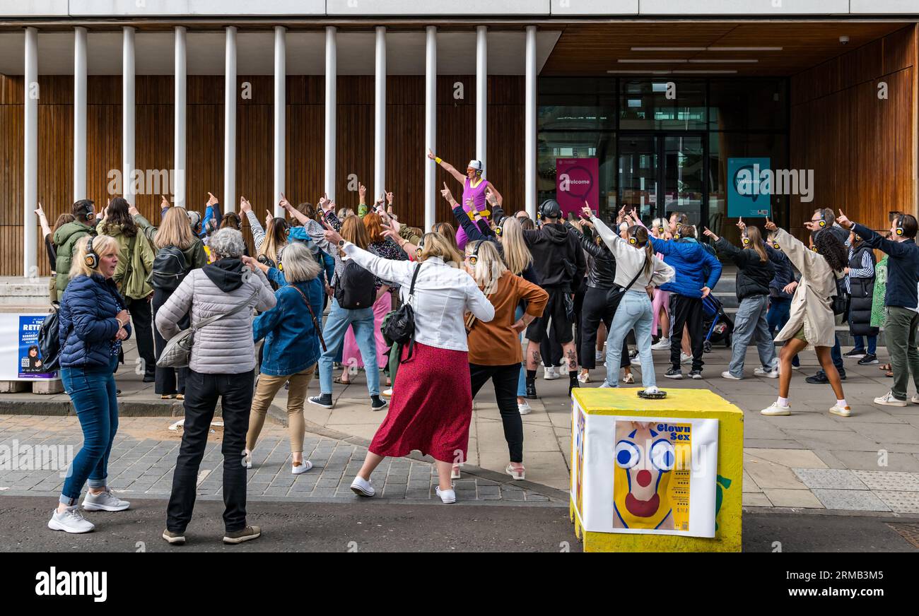Édimbourg, Écosse, Royaume-Uni, 27 août 2023. Silent Disco : un grand groupe aime la musique à travers des écouteurs alors qu'ils sont conduits autour de la ville dansant sur la musique pop seulement ils peuvent entendre. Crédit : Sally Anderson/Alamy Live News Banque D'Images