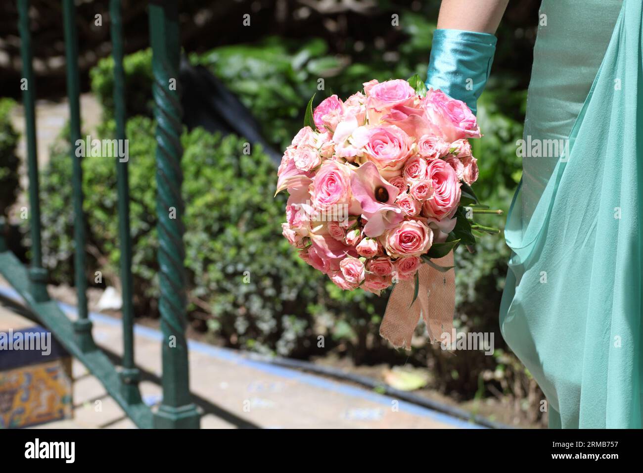 Détail d'une mariée tenant un bouquet de roses dans les jardins du palais royal de l'Alcazar à Séville Banque D'Images