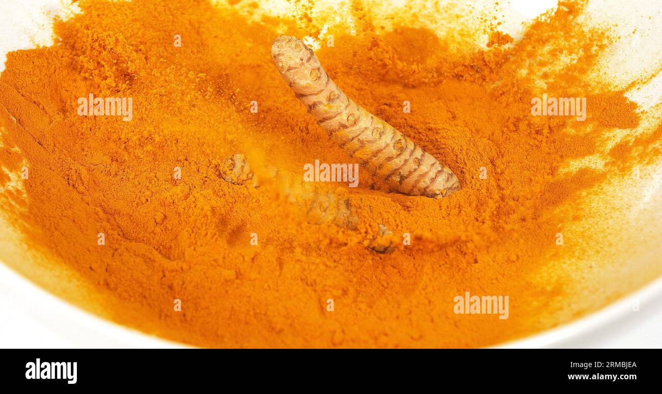 Curcuma, curcuma longa, racine tombant sur poudre de curcuma, épices indiennes Banque D'Images