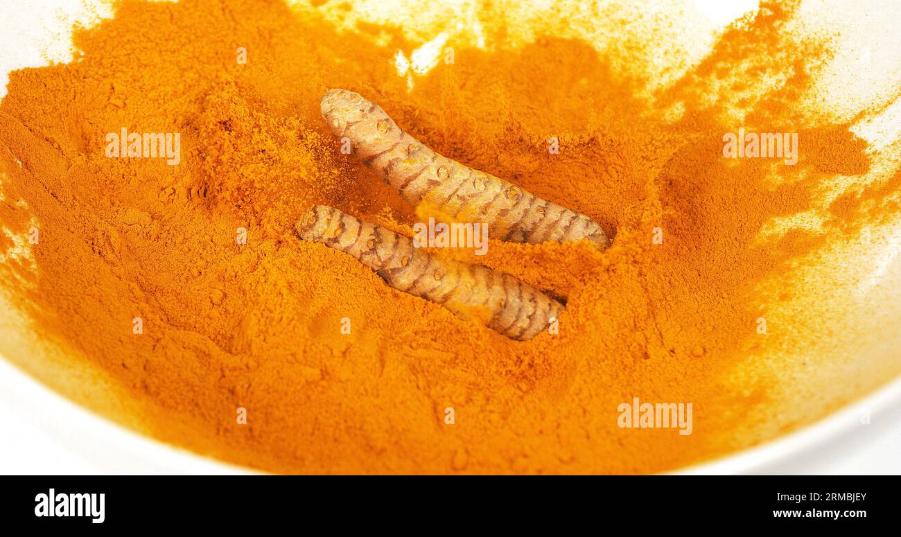 Curcuma, curcuma longa, racine tombant sur poudre de curcuma, épices indiennes Banque D'Images