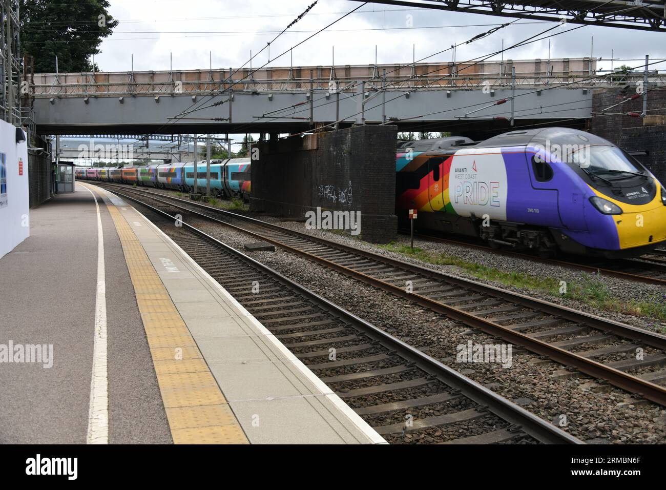 Lichfield Trent Valley Station pendant la fermeture temporaire de la plate-forme 3 de haut niveau avec Avanti Pride Liveried Pendolino 390119 passant en dessous Banque D'Images