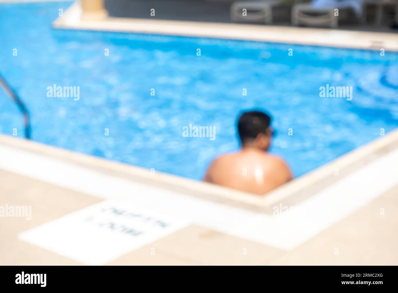Piscine sur le toit, homme nageant dans une petite piscine sur le toit. Homme flou, homme flou dans la piscine Banque D'Images