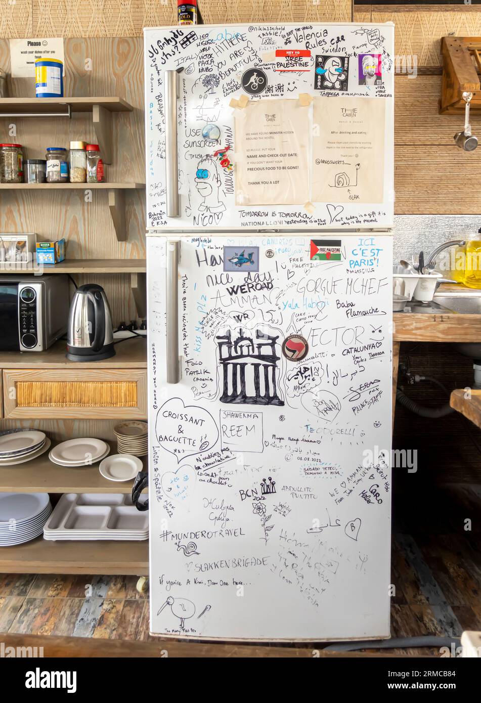 Réfrigérateur dans la cuisine de l'auberge couvert de notes manuscrites, écrits, graffitis d'invités et de visiteurs internationaux Banque D'Images