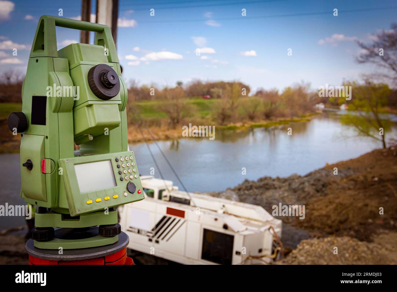 L'instrument Surveyor est pour mesurer le niveau sur le chantier. Grue mobile et perceuse pour forer dans le sol fonctionnent sur le pont trouvé Banque D'Images