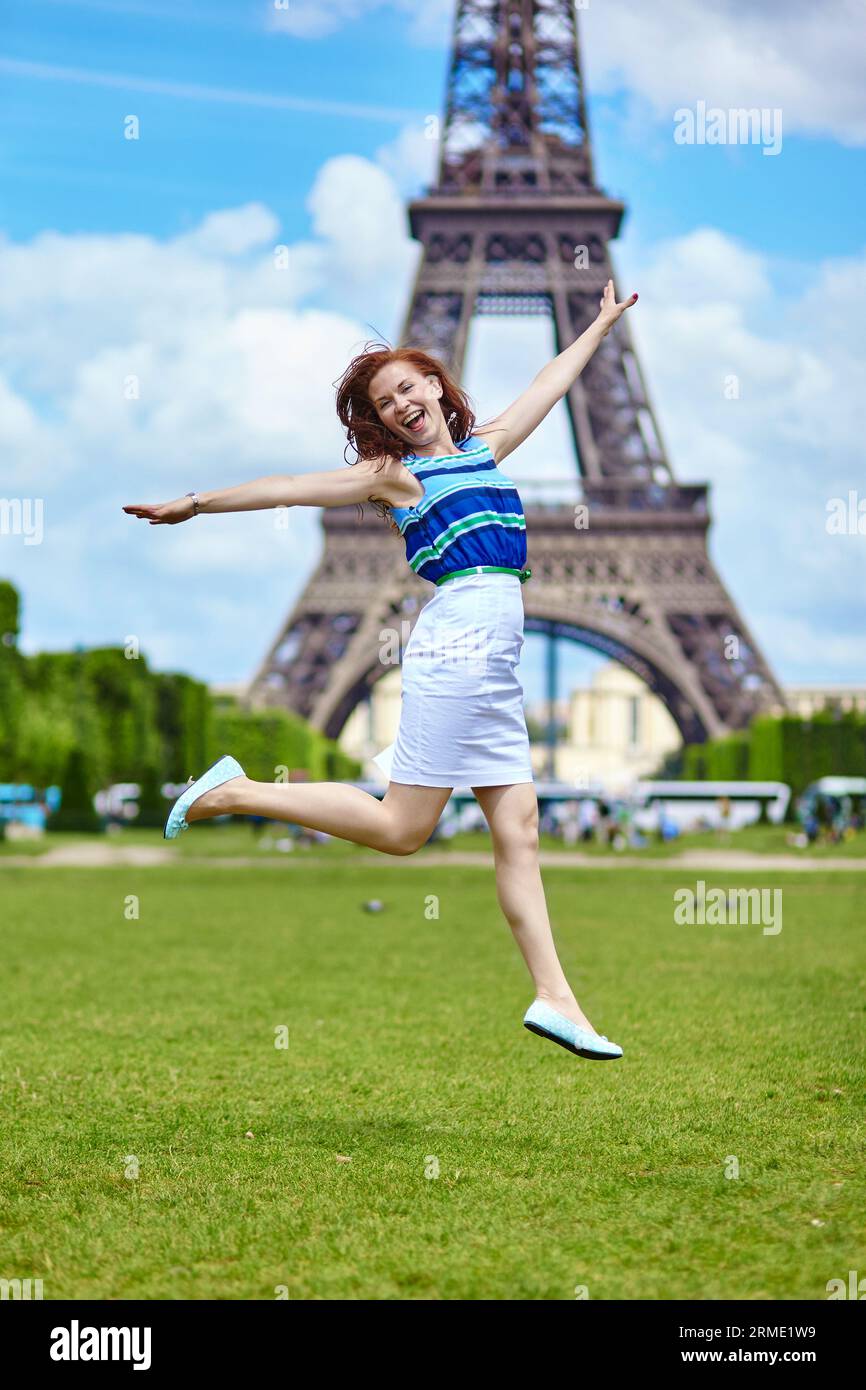 Heureuse belle fille sautant près de la Tour Eiffel à Paris Banque D'Images