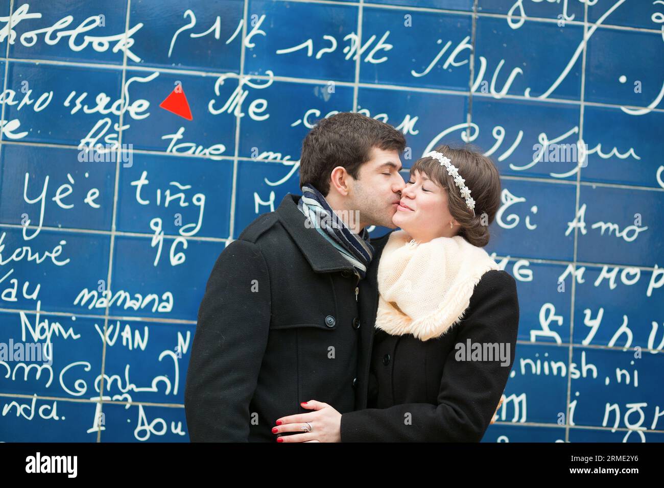 Couple romantique s'embrassant à travers le mur I Love You à Paris Banque D'Images