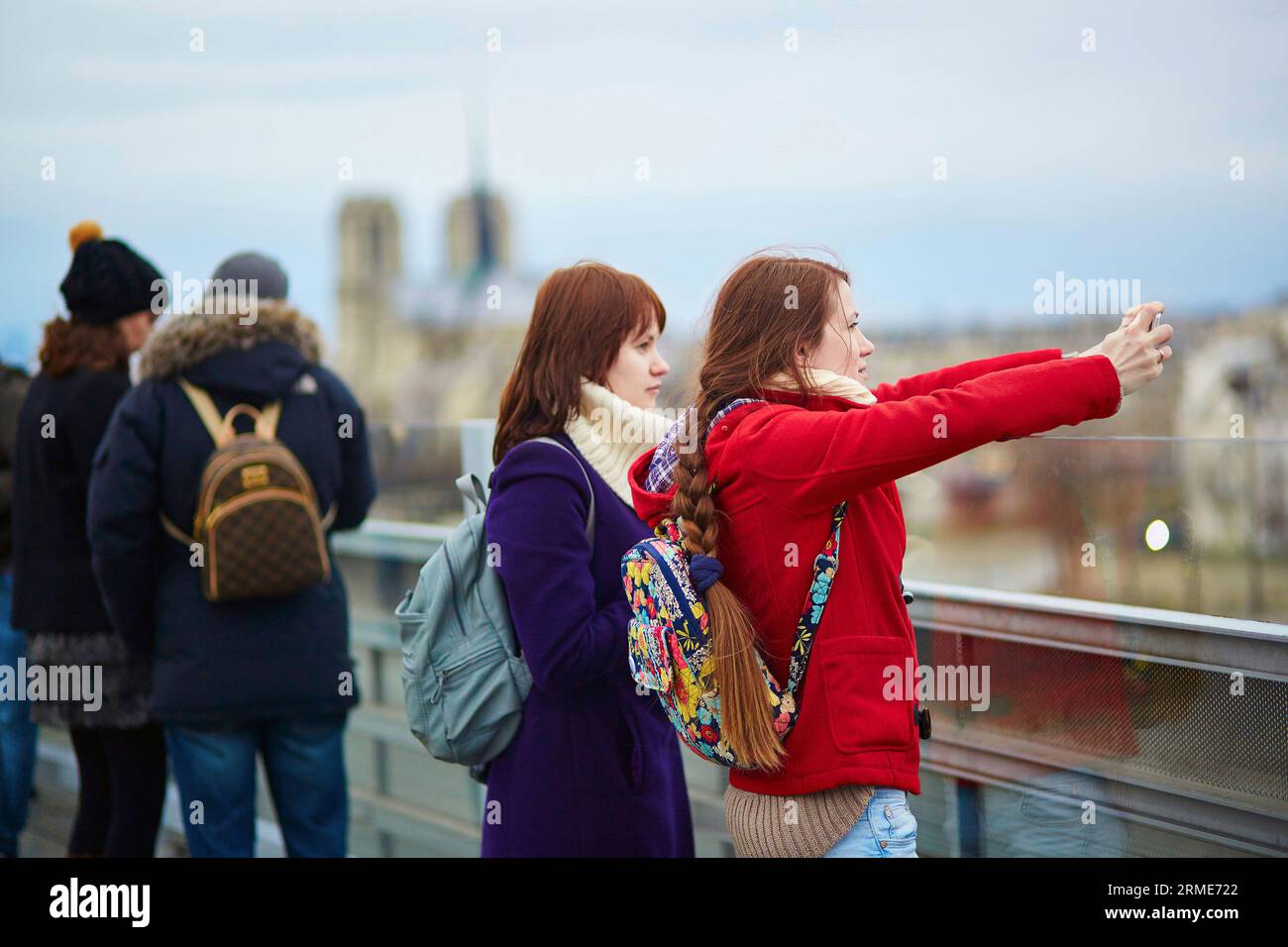 Deux jeunes touristes à Paris, prenant une photo avec un téléphone portable depuis le pont d'observation de l'Institut du monde arabe Banque D'Images