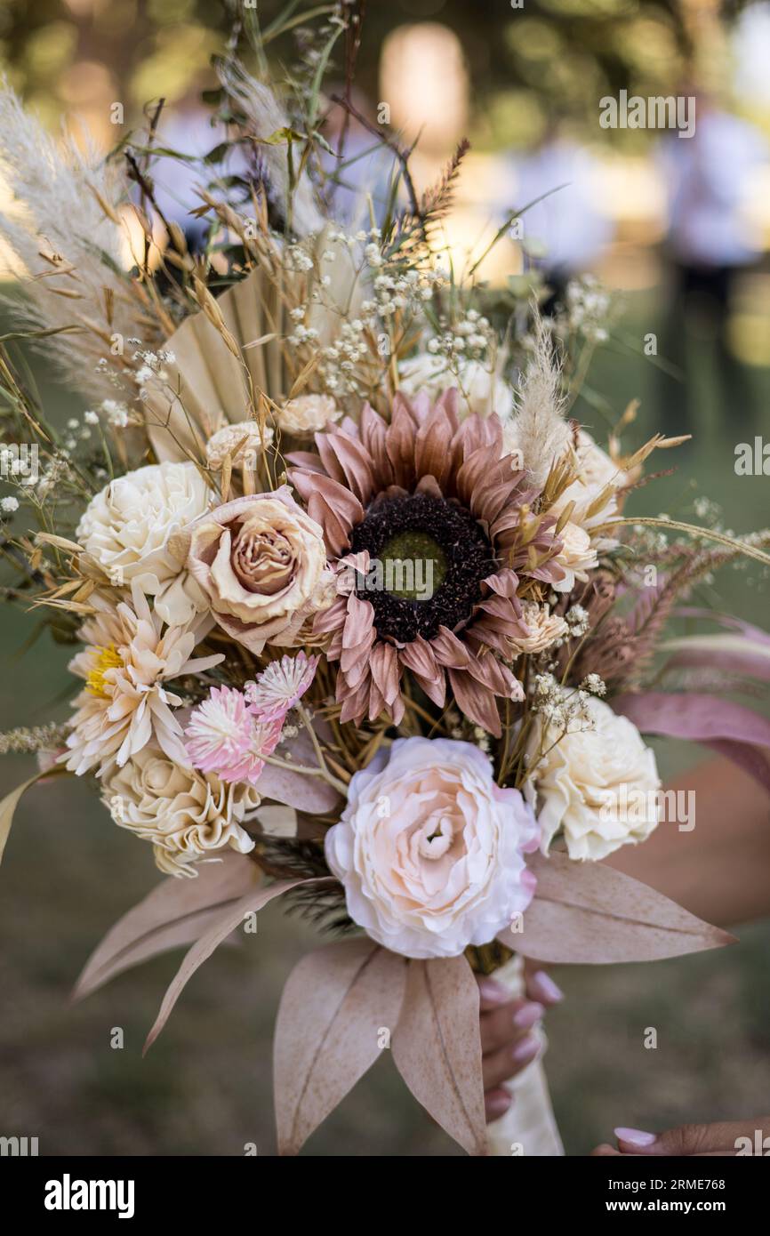 Mariée tenant un bouquet rustique de mariage de fleurs séchées Banque D'Images