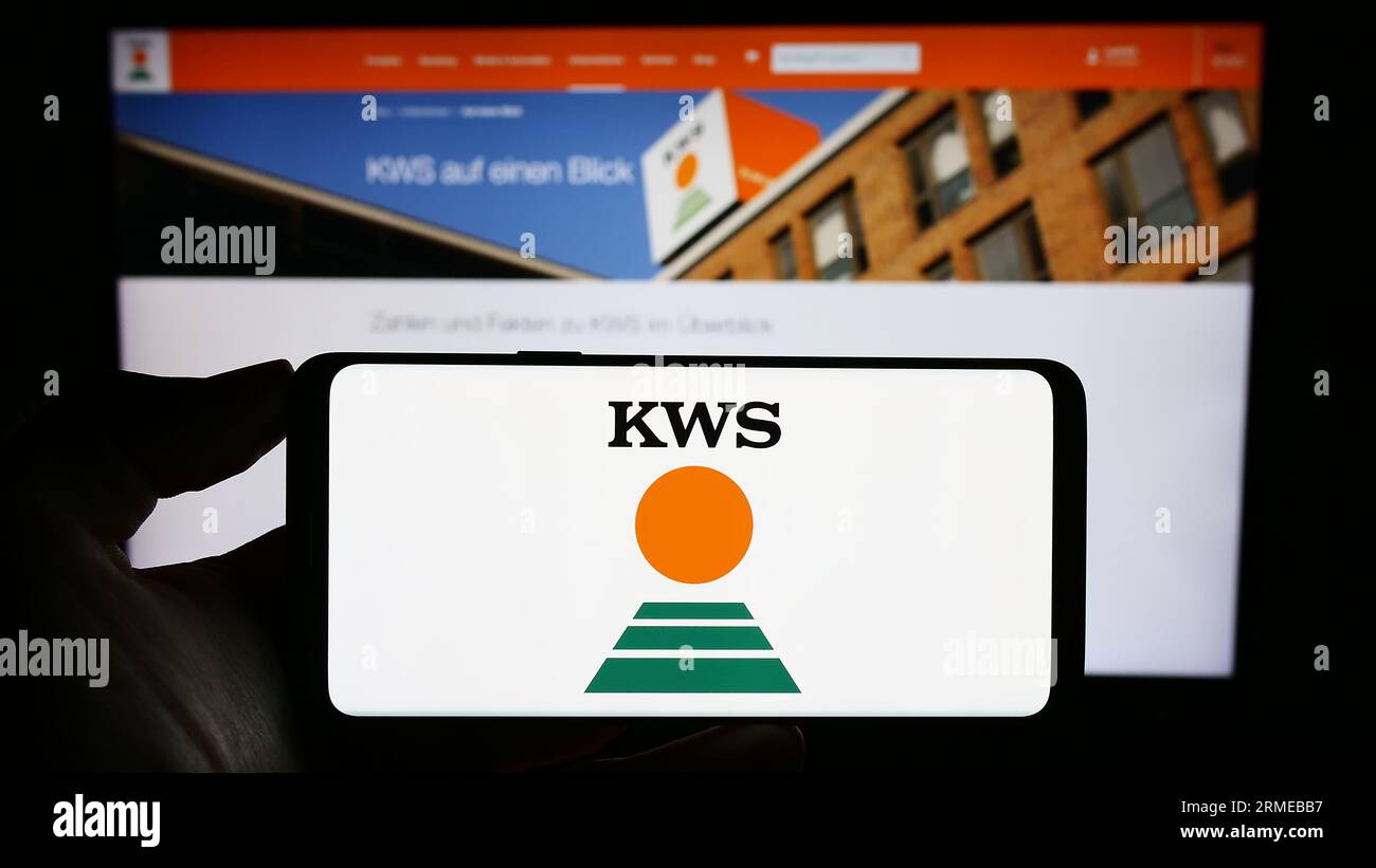 Personne tenant le téléphone portable avec le logo de la société agricole allemande KWS Saat se Co. KGaA sur l'écran devant la page Web. Concentrez-vous sur l'affichage du téléphone. Banque D'Images Personne tenant le téléphone portable avec le logo de la société agricole allemande KWS Saat se Co. KGaA sur l'écran devant la page Web. Concentrez-vous sur l'affichage du téléphone. Banque D'Images