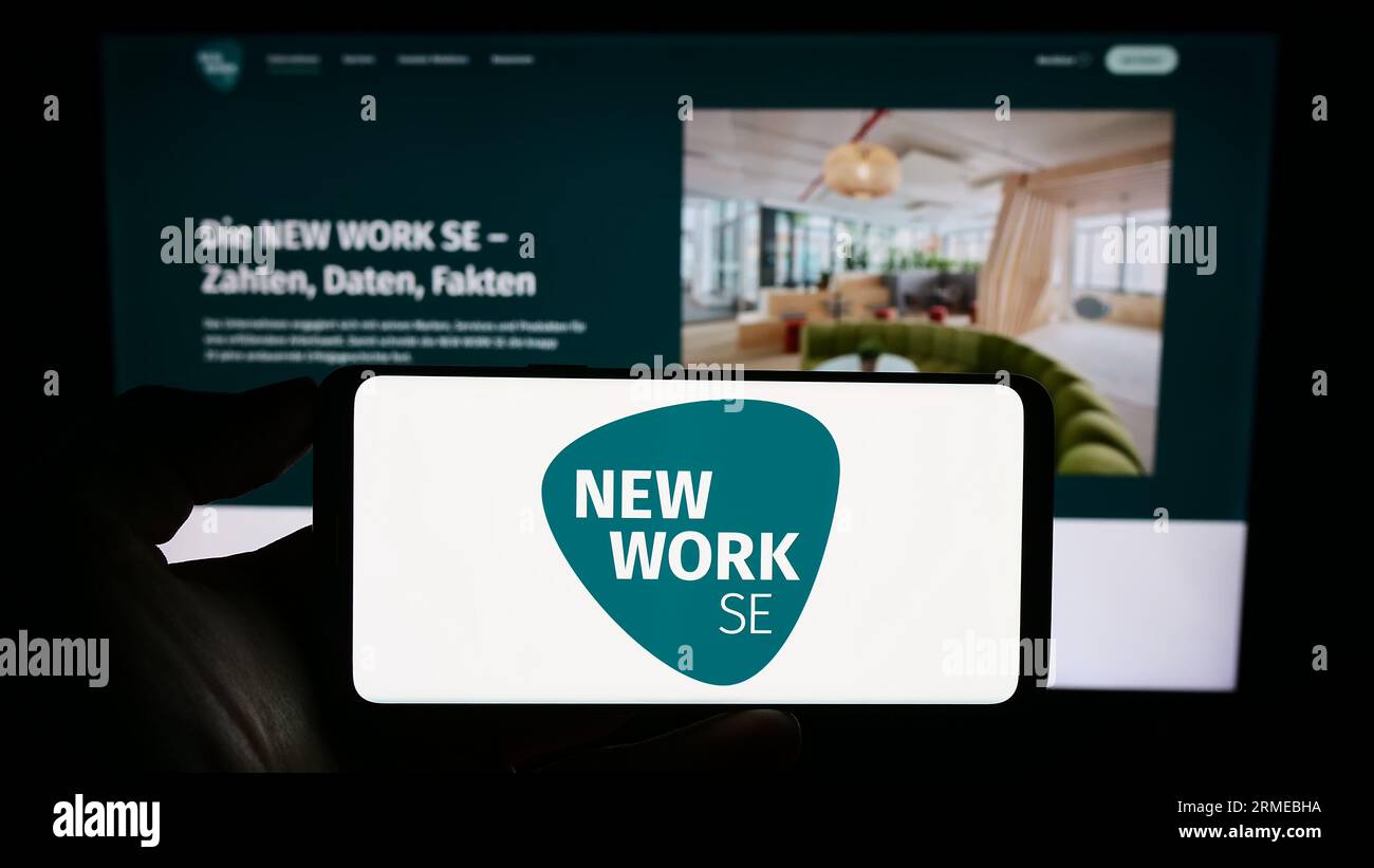 Personne tenant le smartphone avec le logo de la société allemande New Work se (XING) sur l'écran en face du site Web. Concentrez-vous sur l'affichage du téléphone. Banque D'Images