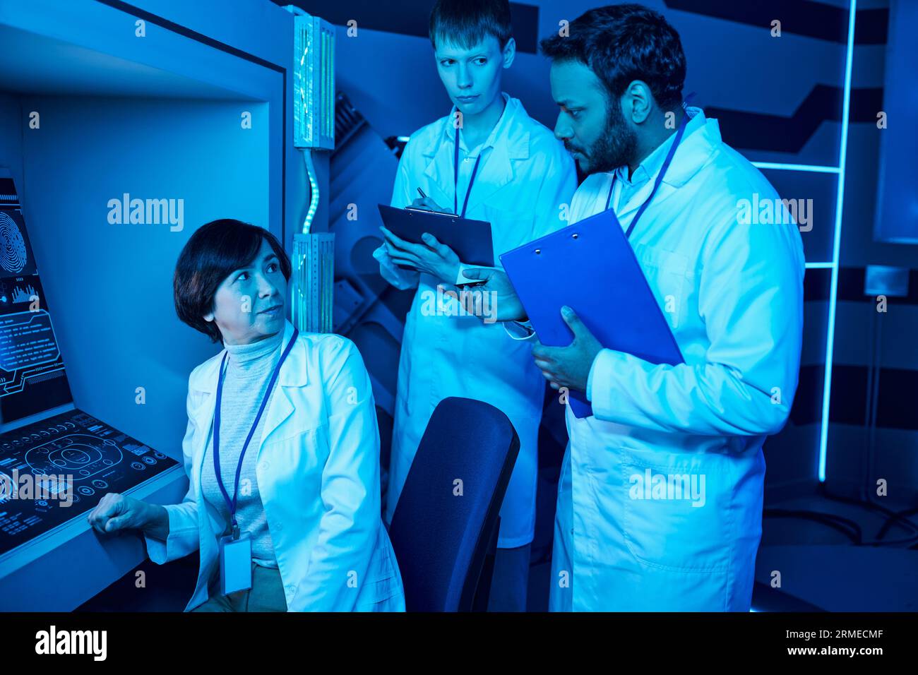 Discours futuriste : trois scientifiques s'engagent dans la discussion près de l'ordinateur au Science Center Banque D'Images