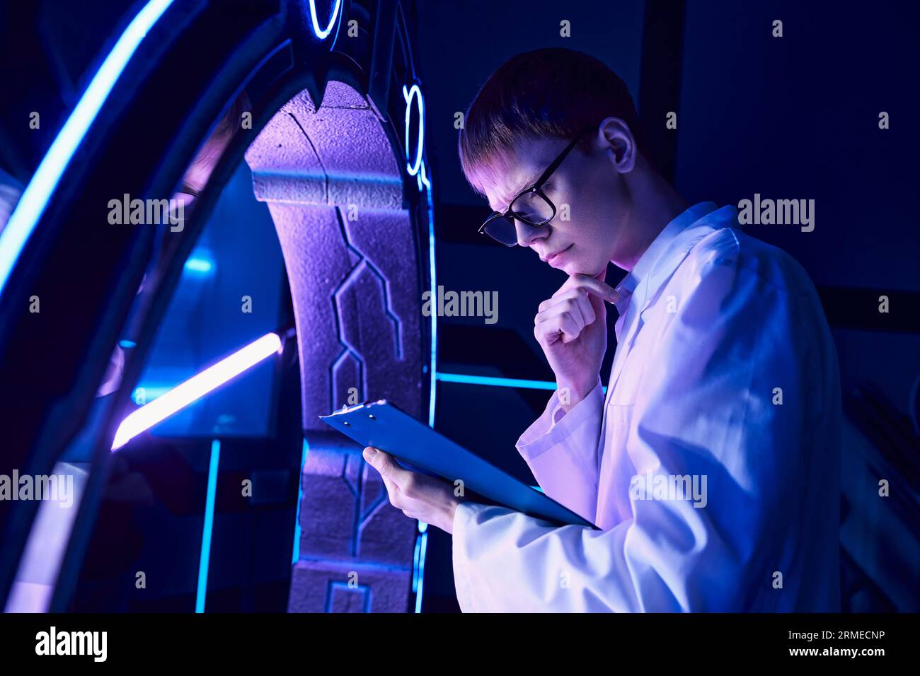 science futuriste, centre de découverte, jeune scientifique avec la pensée de presse-papiers à dispositif innovant Banque D'Images