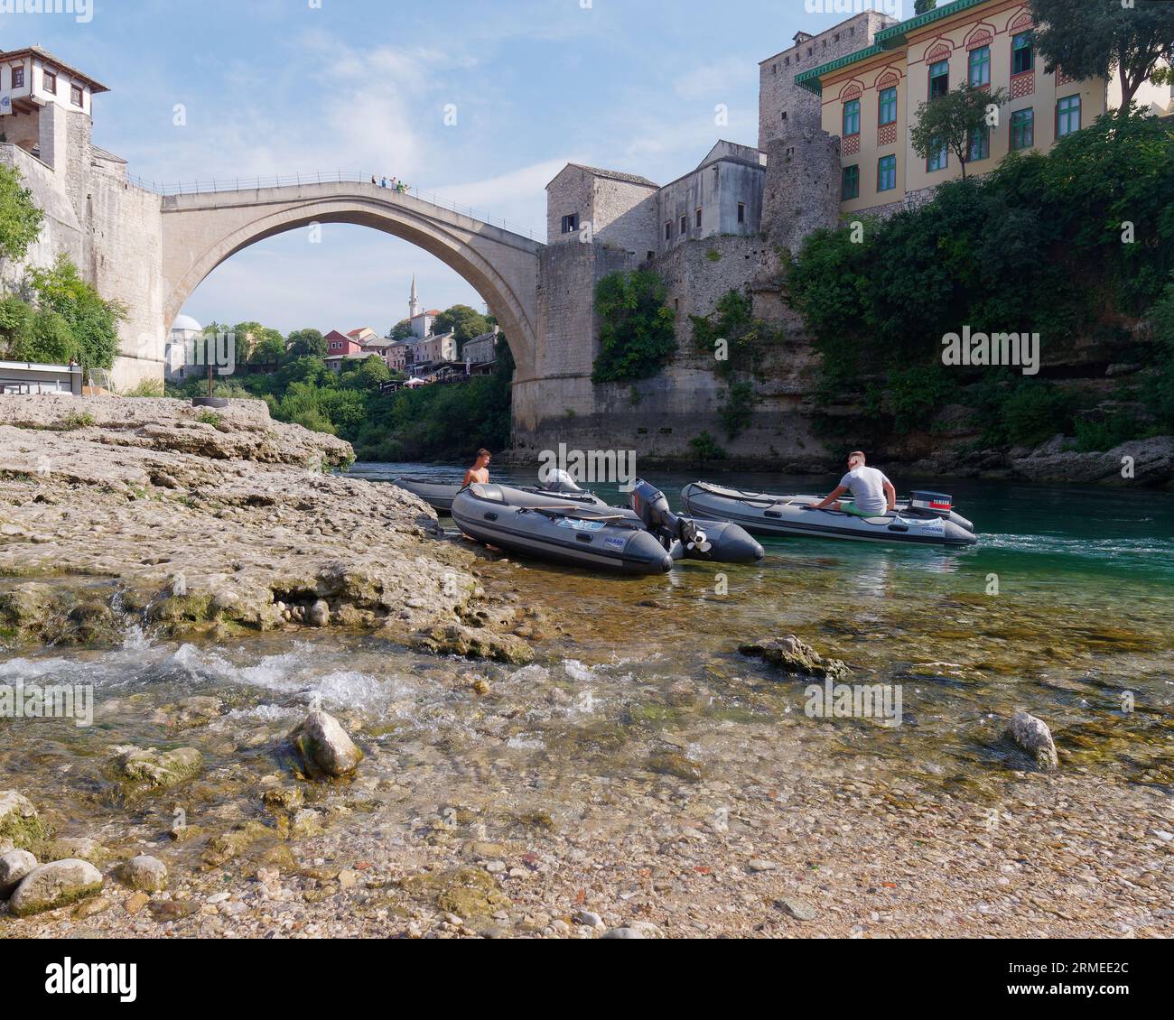 Stari Most (Vieux Pont) avec des bateaux sur la plage le long de la rivière Neretva avec des bateaux. Ville de Mostar, Bosnie-Herzégovine, 26 août 2023. Banque D'Images