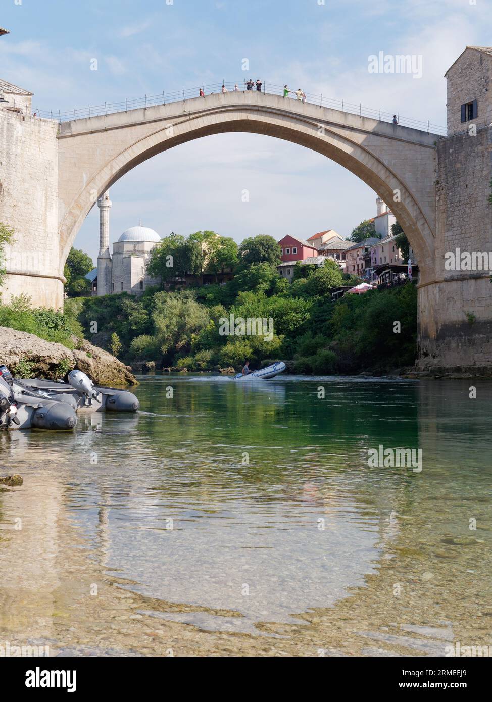 Stari Most (Vieux Pont) avec des bateaux sur la plage le long de la rivière Neretva avec des bateaux. Ville de Mostar, Bosnie-Herzégovine, 26 août 2023. Banque D'Images