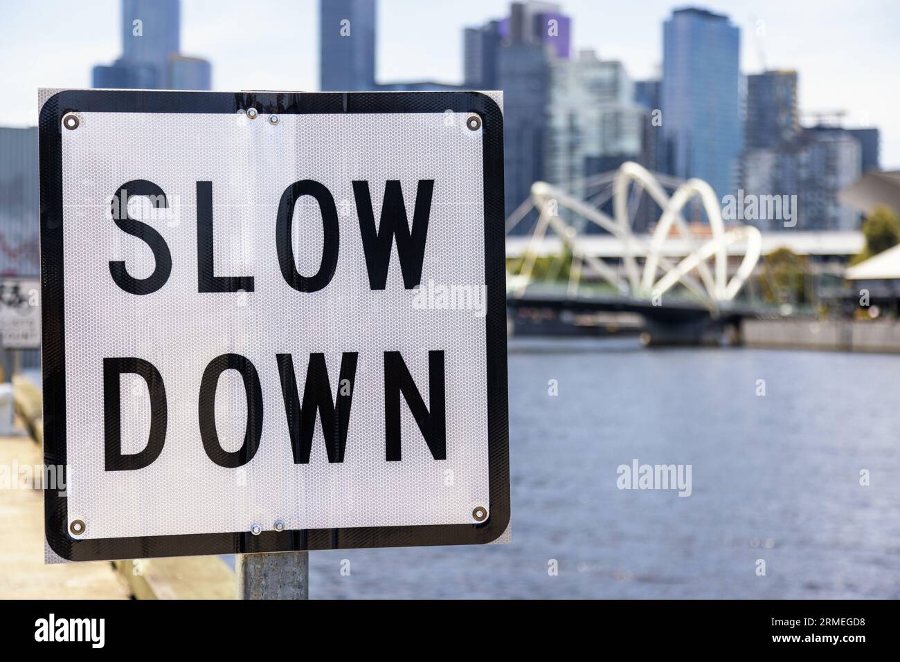 Panneau de ralentissement sur la rivière Yarra à Melbourne, en Australie, un jour d'été avec des bâtiments de la ville et un pont en arrière-plan. Concept Take IT Easy. Banque D'Images