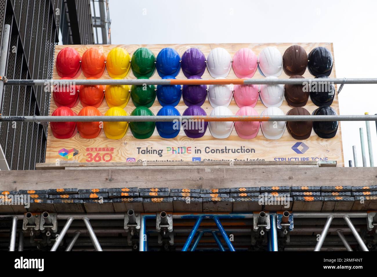 Couleurs multicolores Pride LGBT LGBTQ construction casques de sécurité casques de sécurité casques de sécurité soutenus par Uniqlo sur Southbank Bankside à Londres Royaume-Uni 2023 Banque D'Images