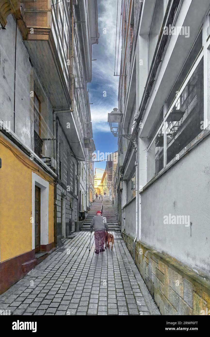 Homme plus âgé avec un chien se dirigeant vers quelques escaliers dans une rue étroite dans le concept de la solitude des gens quand ils atteignent l'âge adulte. Banque D'Images