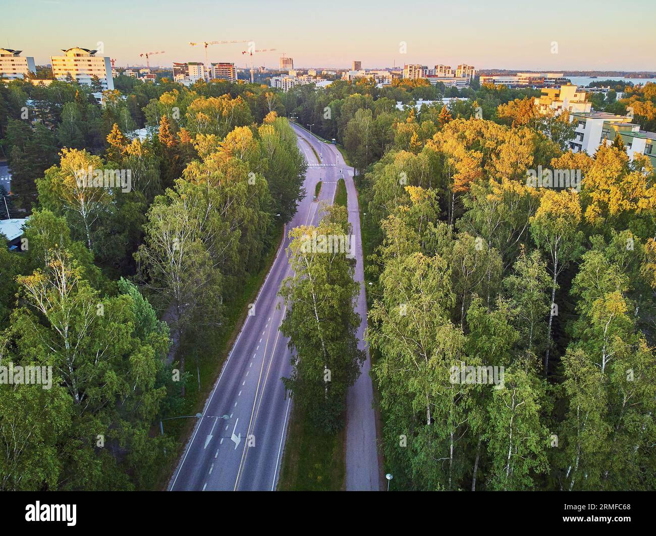 Vue aérienne de la route asphaltée à travers la forêt près d'Espoo, banlieue résidentielle d'Helsinki, Finlande Banque D'Images