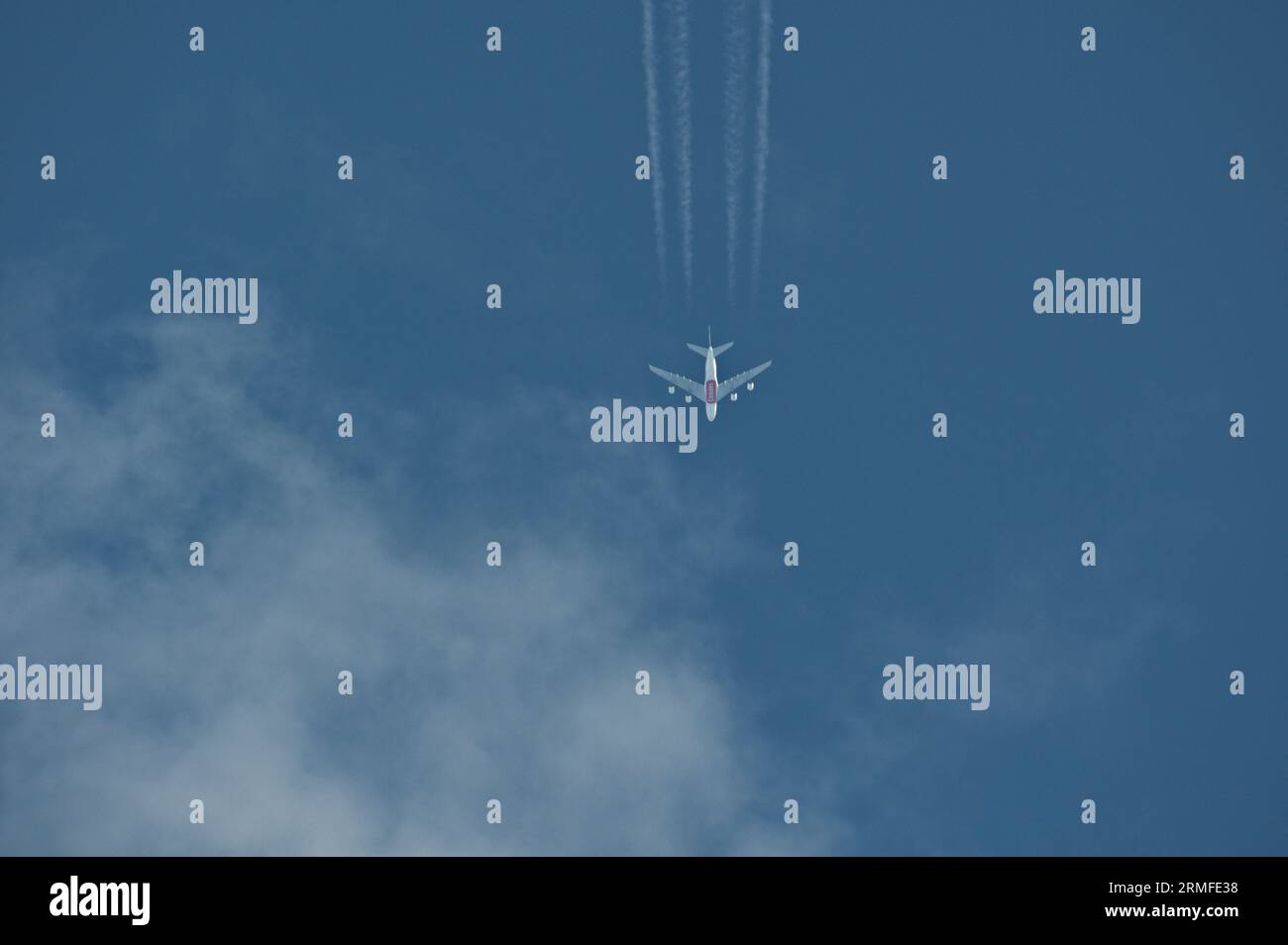 L'avion de transport commercial rend visible la trace de chemtrails sur le ciel bleu. Théorie du complot. Banque D'Images