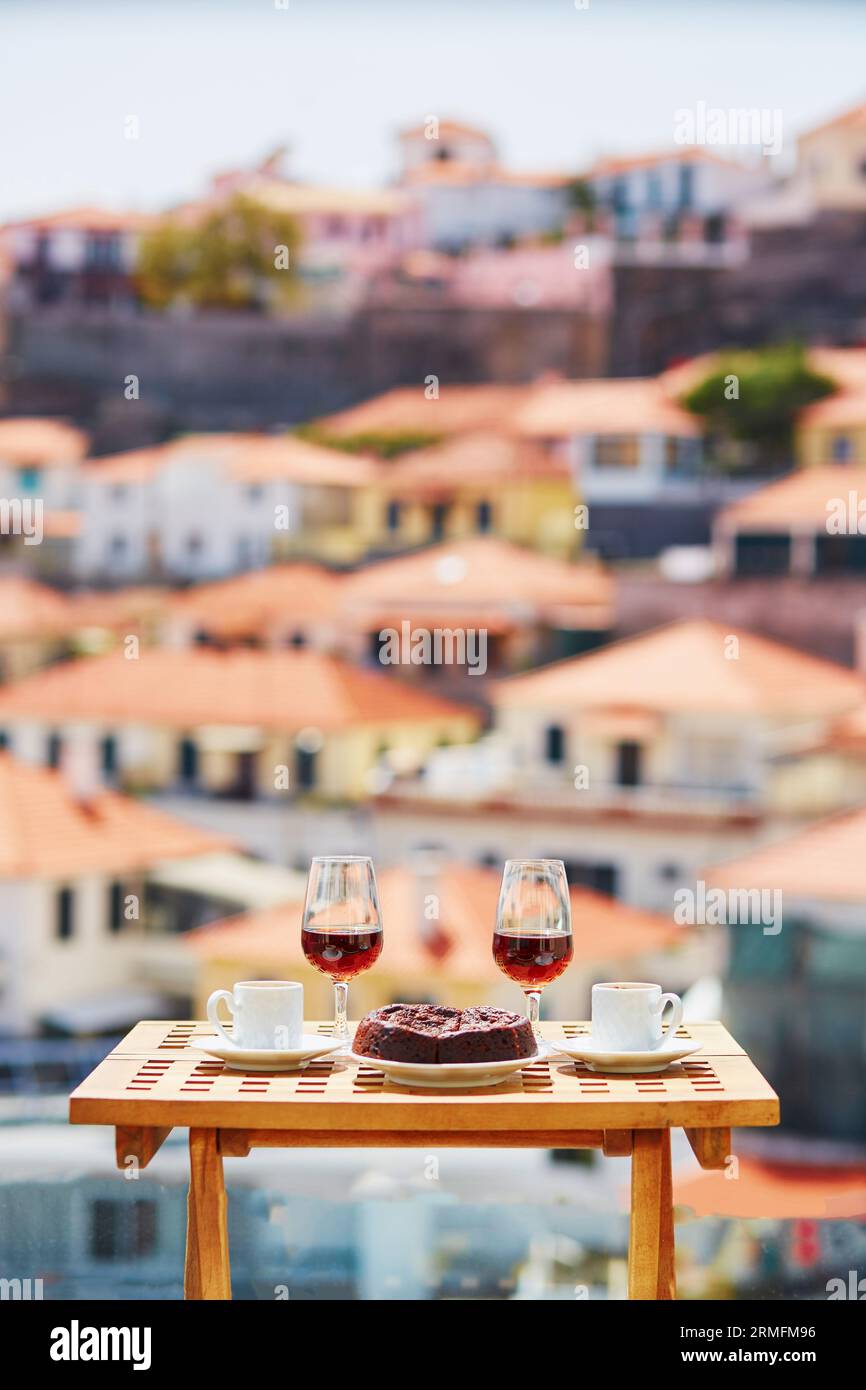 Deux verres de vin de Madère, deux tasses de café expresso frais et dessert traditionnel portugais au miel et aux noix Bolo de mel dans un café avec vue sur Funch Banque D'Images