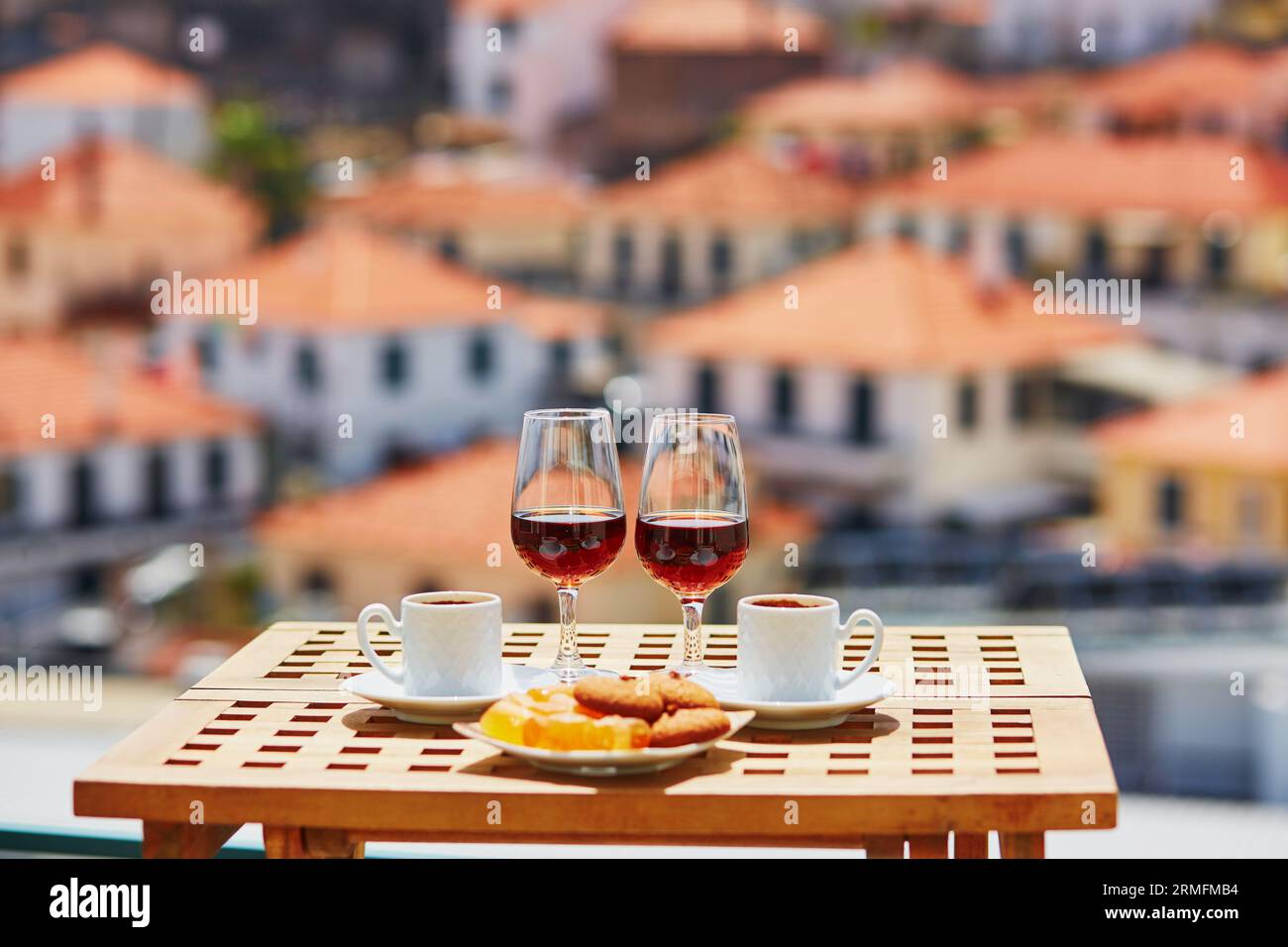 Deux verres de vin de Madère, deux tasses de café expresso frais et des bonbons traditionnels portugais dans un café avec vue sur la ville de Funchal, Madère, Portugal Banque D'Images