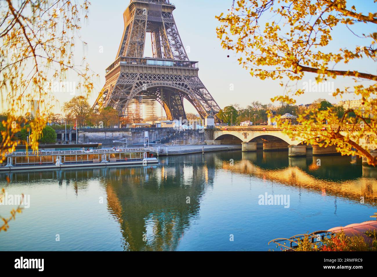 Vue panoramique sur la tour Eiffel et le pont Iéna sur la Seine avec des branches d'arbres avec les premiers feuilles tôt le matin. Printemps à Paris, France Banque D'Images