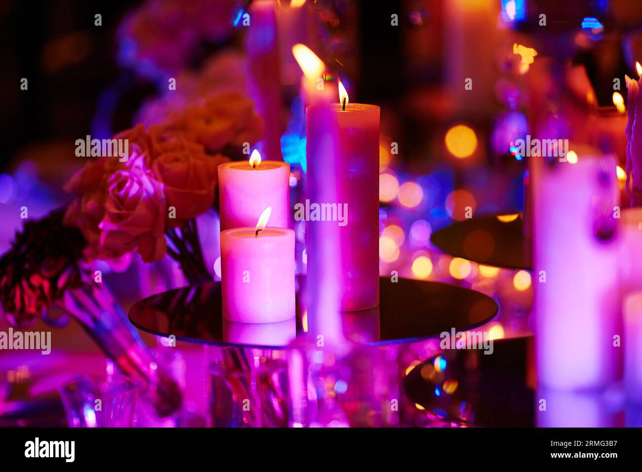 Belle table sertie de bougies pour un événement festif, fête ou réception de mariage, à la lumière violette Banque D'Images