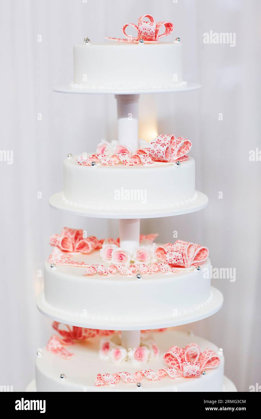 Gâteau de mariage blanc décoré de fleurs de sucre rose Banque D'Images