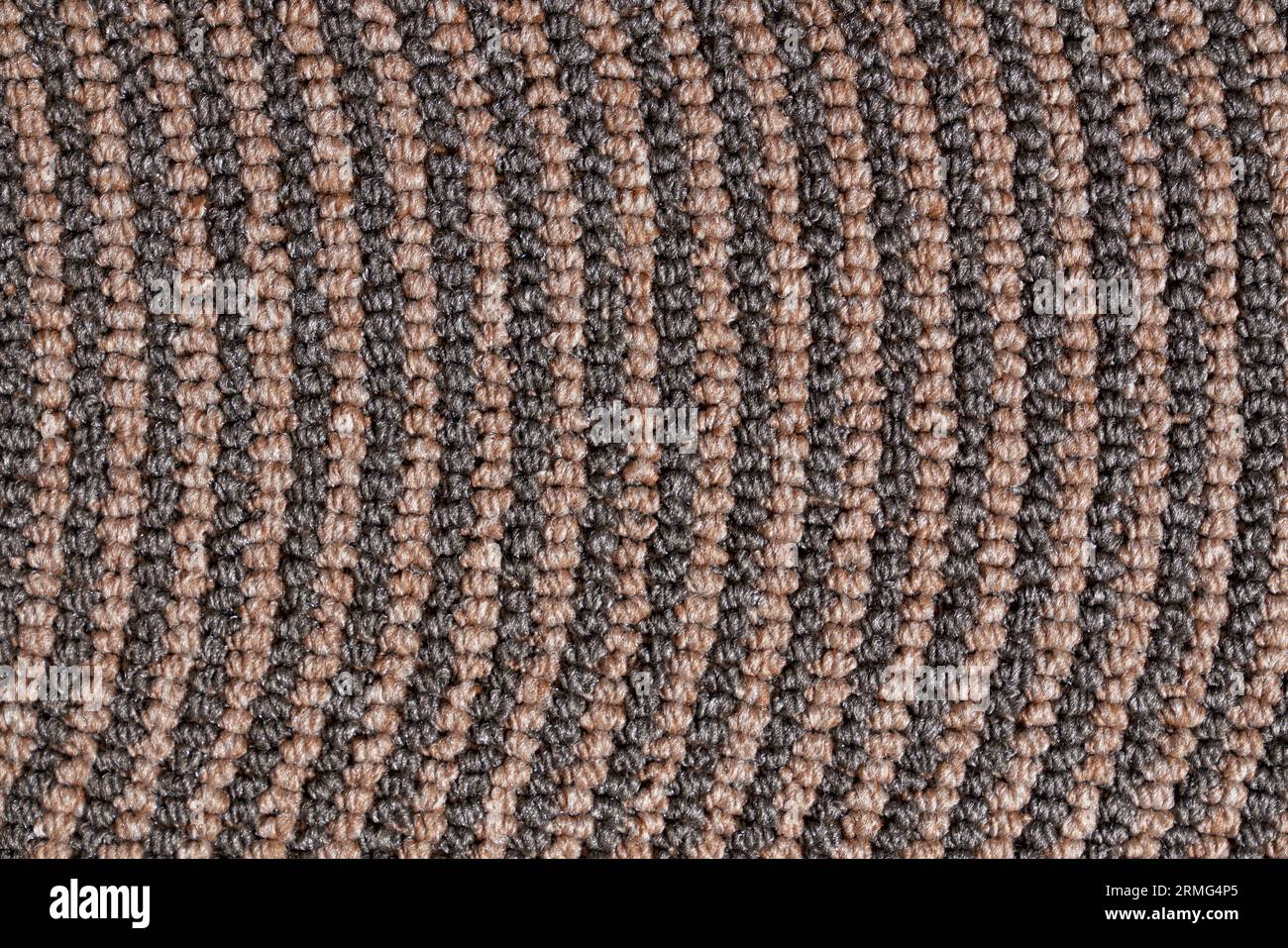 Texture en relief foncé du bord de tapis enroulé pour un arrière-plan inhabituel. Gros plan du motif marron des rangées de jute tricotées collantes synthétiques. Concept de textur Banque D'Images Texture en relief foncé du bord de tapis enroulé pour un arrière-plan inhabituel. Gros plan du motif marron des rangées de jute tricotées collantes synthétiques. Concept de textur Banque D'Images