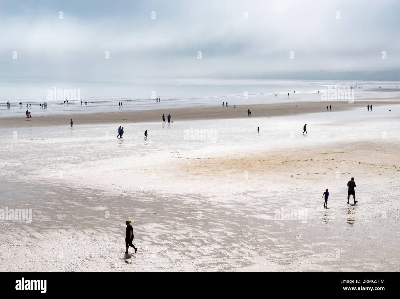 Filey Yorkshire beaucoup de gens marchent sur la plage de Filey Beach Filey Bay dans la brume de mer Filey North Yorkshire UK GB Europe L S Lowry style Banque D'Images