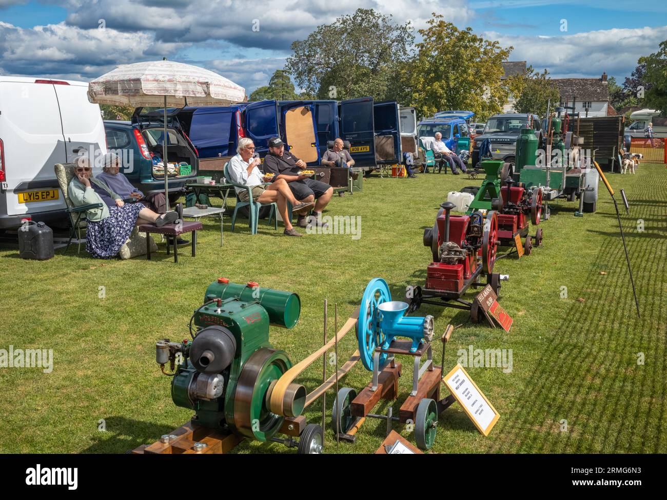 Les passionnés de moteurs stationnaires vintage s'assoient et exposent leurs machines lors d'une fête de village à Wisborough Green, West Sussex, Royaume-Uni. Banque D'Images