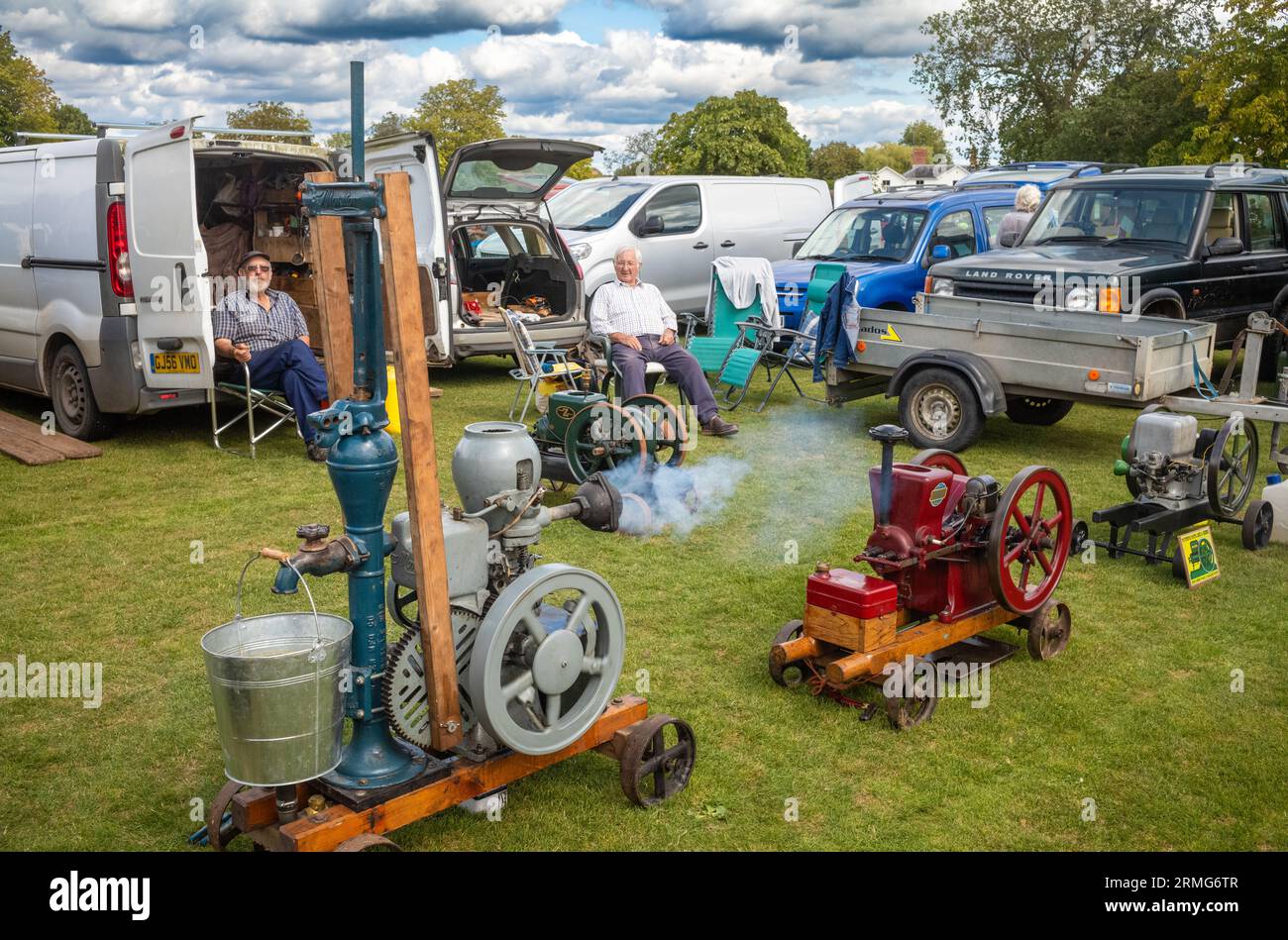 Deux passionnés de moteurs stationnaires vintage âgés s'assoient et montrent leurs machines à une fête de village à Wisborough Green, West Sussex, Royaume-Uni. Banque D'Images