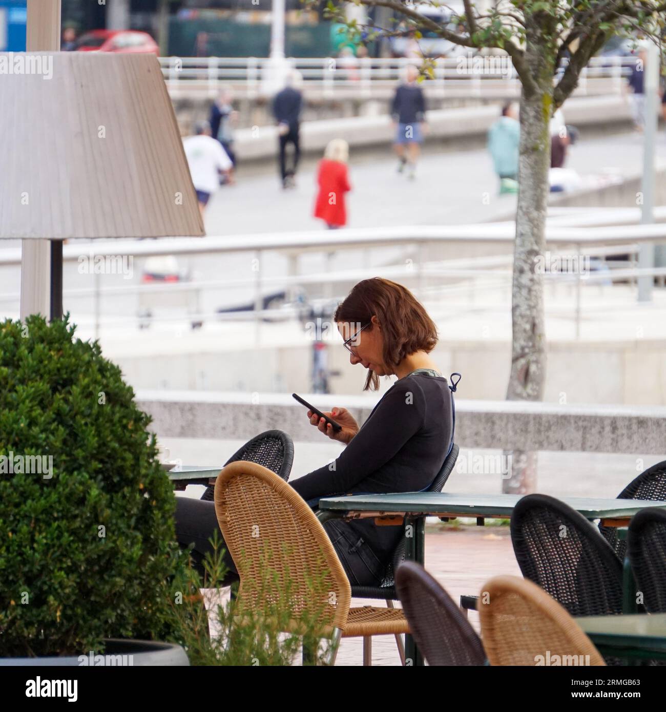 personne marchant dans la rue et envoyant des sms avec le smartphone Banque D'Images